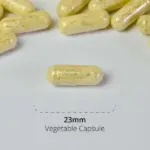 Close-up of a 23mm vegetable capsule among several others, representing high-quality nutritional supplements from Synergistics Europe, designed to support specific metabolic types according to the HealthExcel System of Metabolic Typing®.